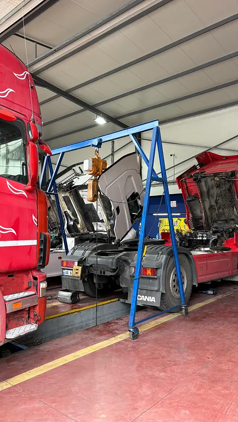 Kamionë të kuq Scania me kabinat e ngritura në servis